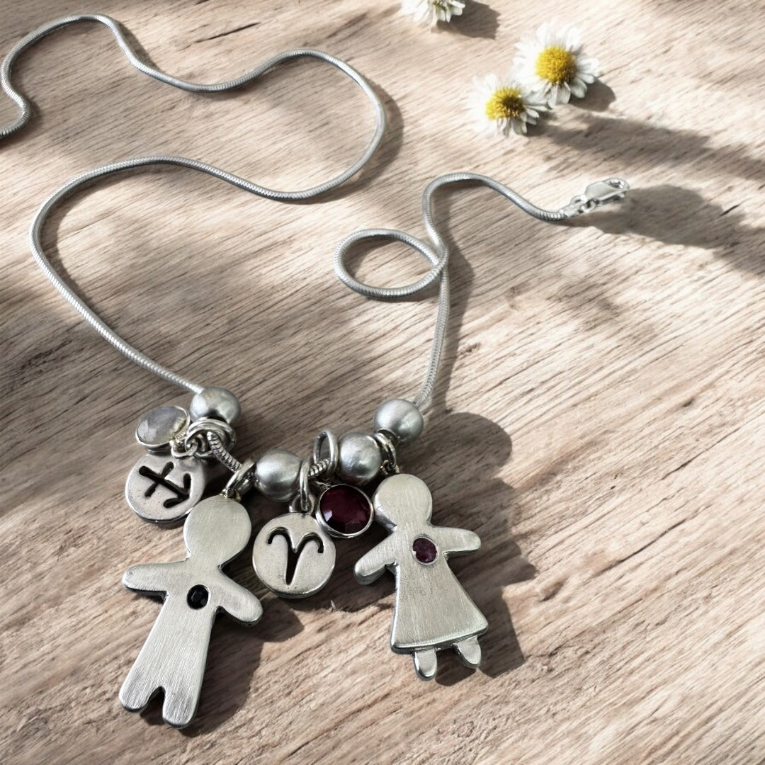 Handcrafted silver necklace with boy and girl charms, featuring blue and pink sapphires – personalized mother’s gift