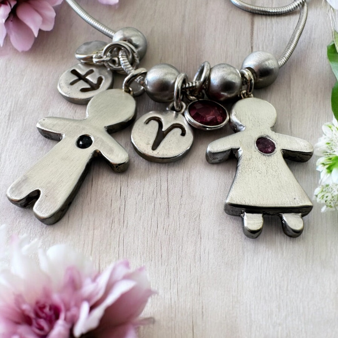 Handcrafted silver necklace with boy and girl charms, featuring blue and pink sapphires – personalized mother’s gift