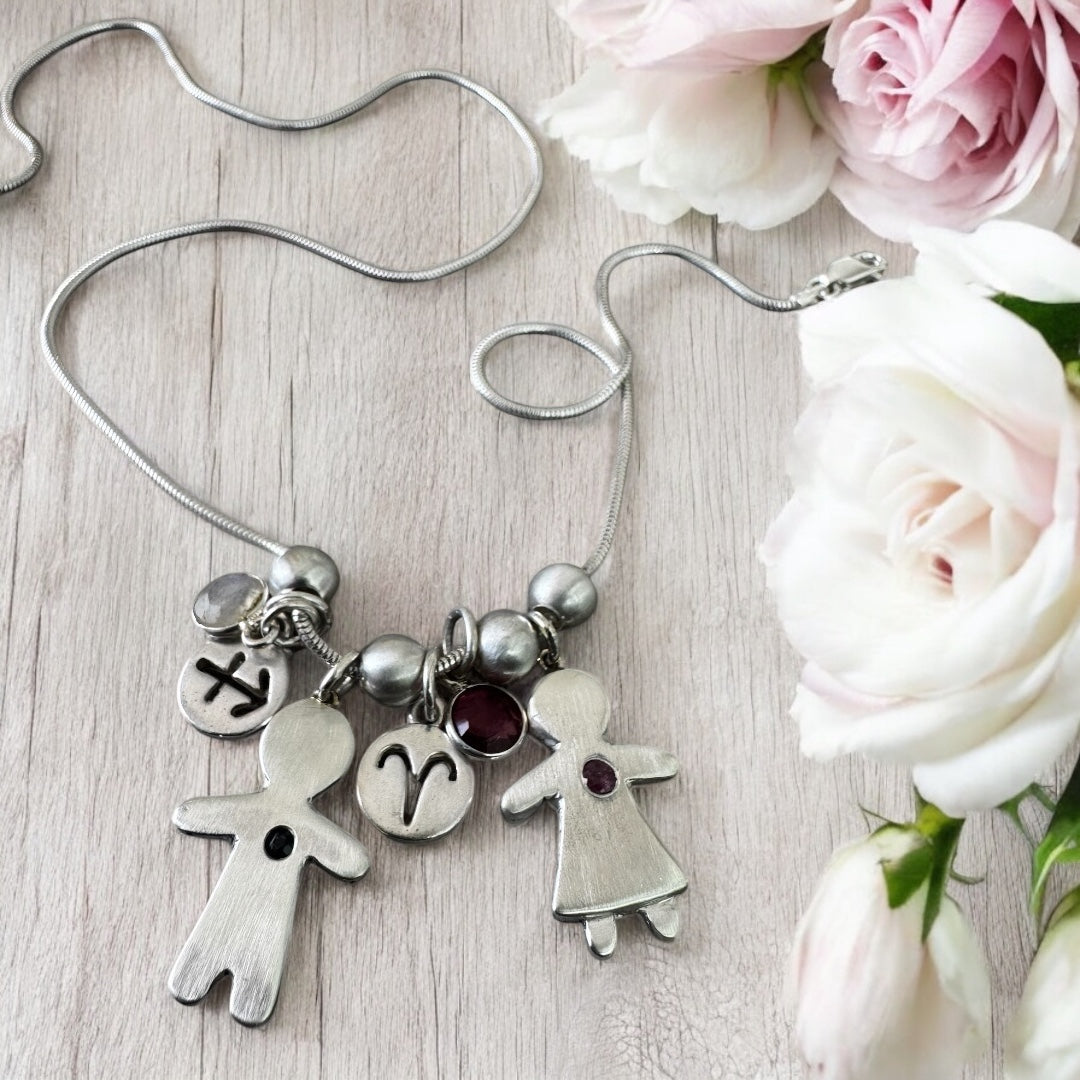 Handcrafted silver necklace with boy and girl charms, featuring blue and pink sapphires – personalized mother’s gift