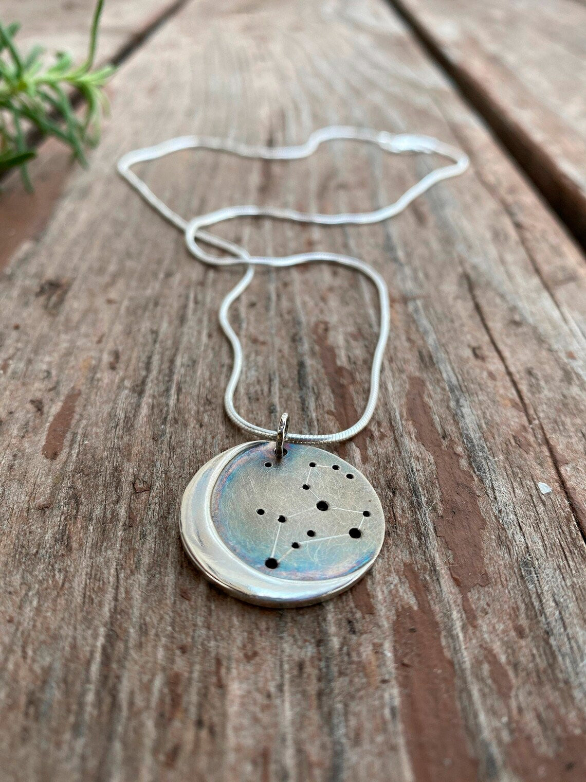 Embrace celestial beauty with our Silver Moon Zodiac Necklace. Each constellation represents a zodiac sign, custom-made just for you. Handcrafted from high-quality silver, this pendant features an oxidized night sky. The perfect birthday or holiday gift for astrology enthusiasts.