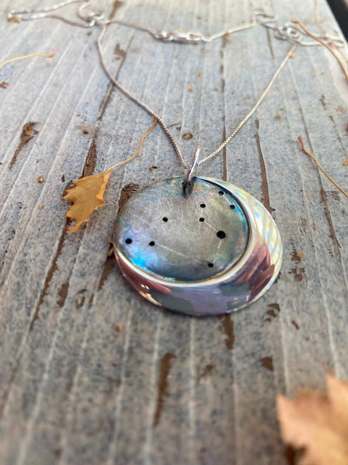 Embrace celestial beauty with our Silver Moon Zodiac Necklace. Each constellation represents a zodiac sign, custom-made just for you. Handcrafted from high-quality silver, this pendant features an oxidized night sky. The perfect birthday or holiday gift for astrology enthusiasts.
