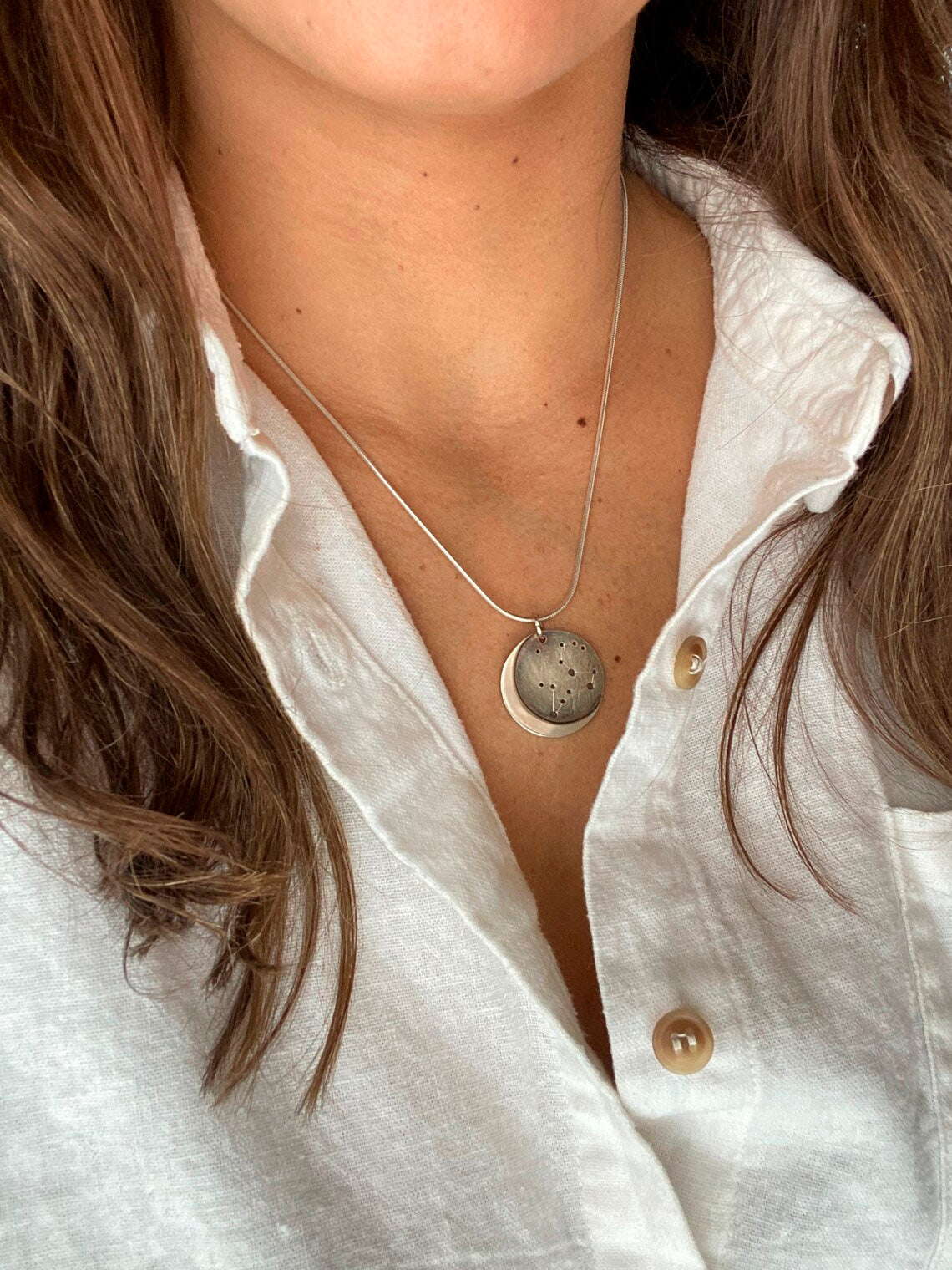 Embrace celestial beauty with our Silver Moon Zodiac Necklace. Each constellation represents a zodiac sign, custom-made just for you. Handcrafted from high-quality silver, this pendant features an oxidized night sky. The perfect birthday or holiday gift for astrology enthusiasts.