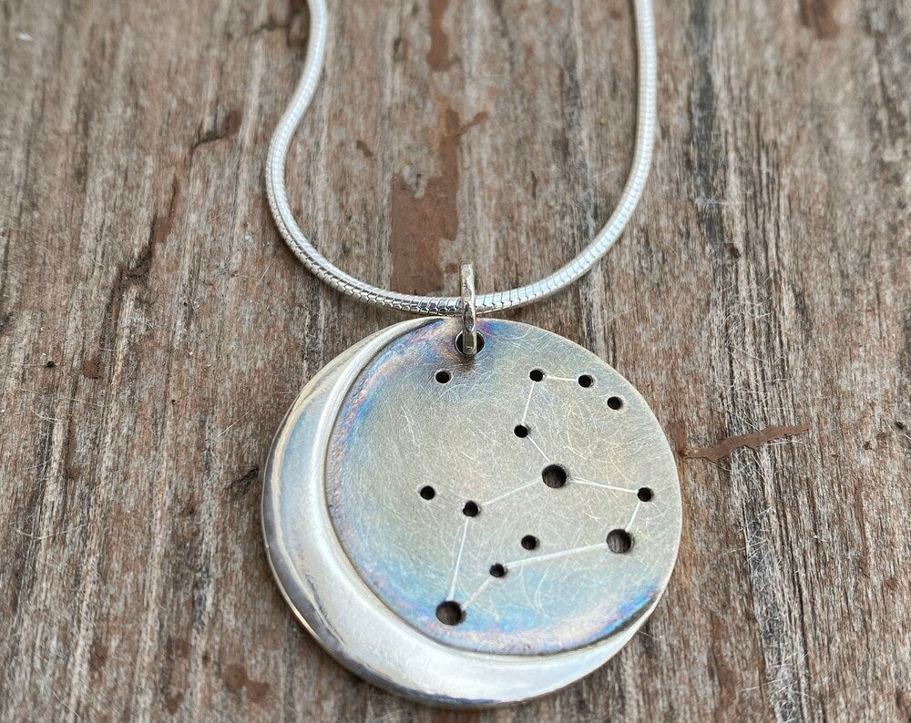 Embrace celestial beauty with our Silver Moon Zodiac Necklace. Each constellation represents a zodiac sign, custom-made just for you. Handcrafted from high-quality silver, this pendant features an oxidized night sky. The perfect birthday or holiday gift for astrology enthusiasts.