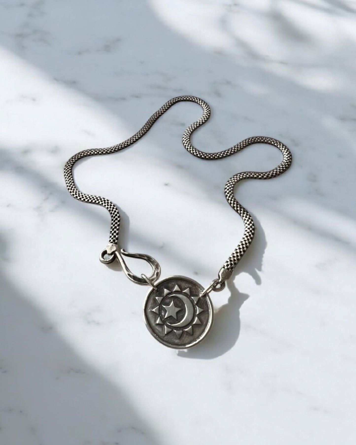 Colar com pingente celestial. Colar com pingente prateado.