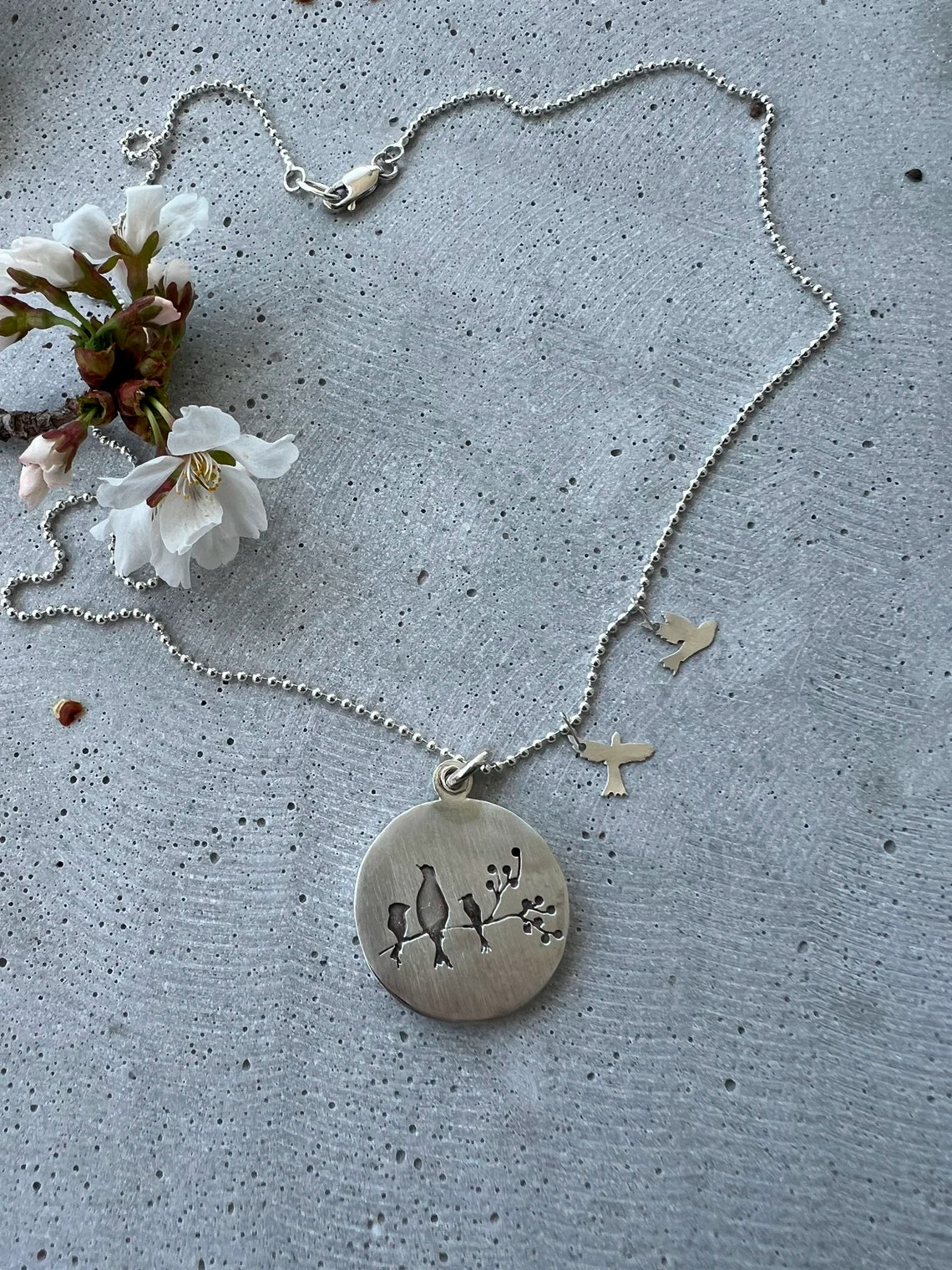 Handmade memorial jewelry with a 30mm locket. Each piece is unique, customizable, and features a big bird representing the mom. Choose the little birds (kids) quantities. Includes a 20-inch dot chain