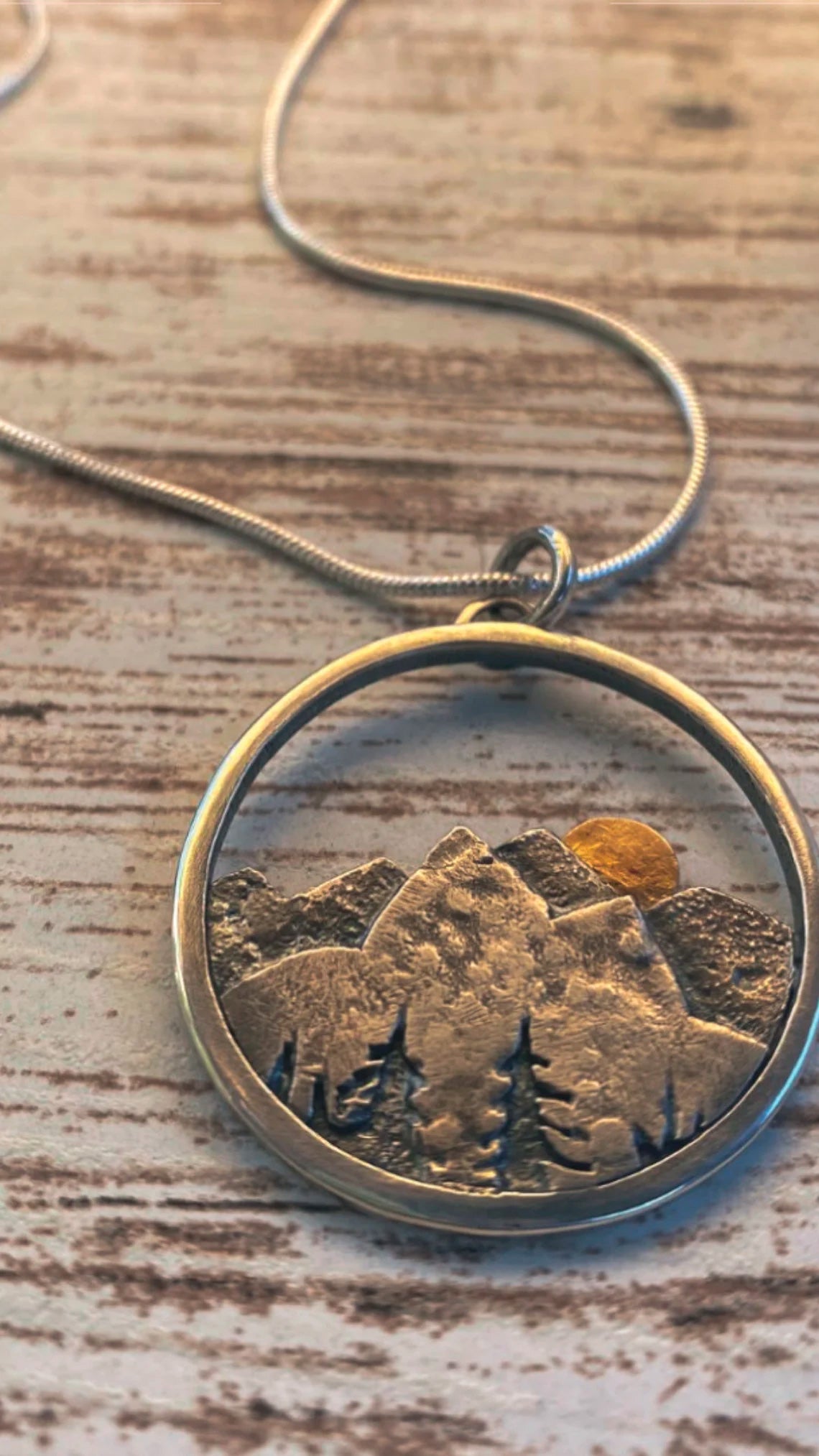 Embrace the beauty of the outdoors with our Sunset Mountain Necklace. Crafted in silver and 14k yellow gold, the 30 mm diameter pendant features a solid gold sun atop the mountains. Whether you’re biking, hiking, or skiing, this design celebrates the adventurous spirit of mountain lovers!