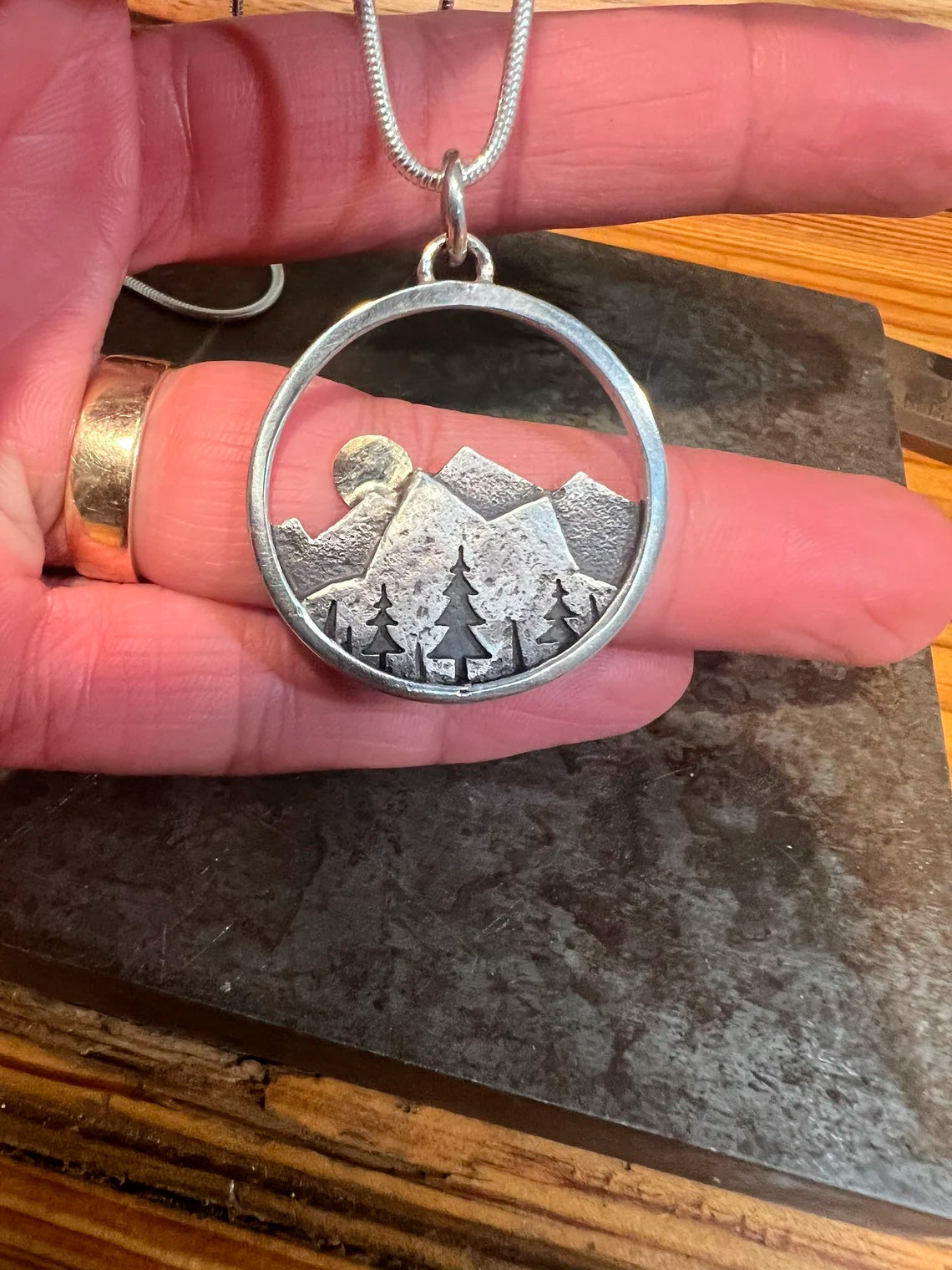 Embrace the beauty of the outdoors with our Sunset Mountain Necklace. Crafted in silver and 14k yellow gold, the 30 mm diameter pendant features a solid gold sun atop the mountains. Whether you’re biking, hiking, or skiing, this design celebrates the adventurous spirit of mountain lovers!