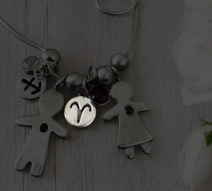 Handcrafted silver necklace with boy and girl charms, featuring blue and pink sapphires – personalized mother’s gift