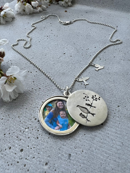 Handmade memorial jewelry with a 30mm locket. Each piece is unique, customizable, and features a big bird representing the mom. Choose the little birds (kids) quantities. Includes a 20-inch dot chain