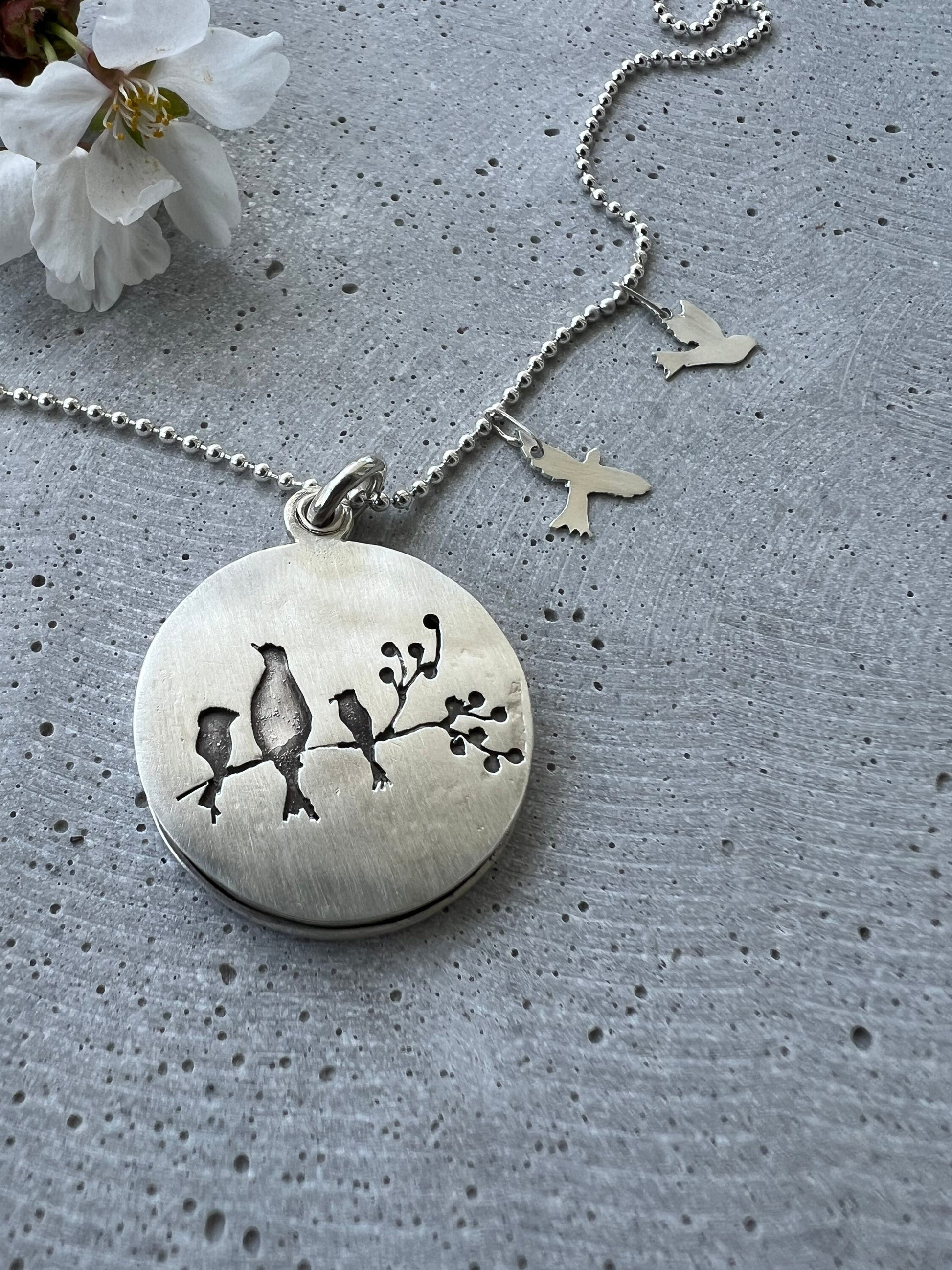 Handmade memorial jewelry with a 30mm locket. Each piece is unique, customizable, and features a big bird representing the mom. Choose the little birds (kids) quantities. Includes a 20-inch dot chain