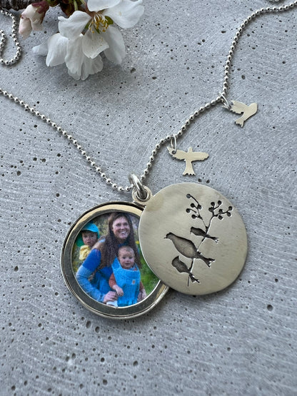 Handmade memorial jewelry with a 30mm locket. Each piece is unique, customizable, and features a big bird representing the mom. Choose the little birds (kids) quantities. Includes a 20-inch dot chain