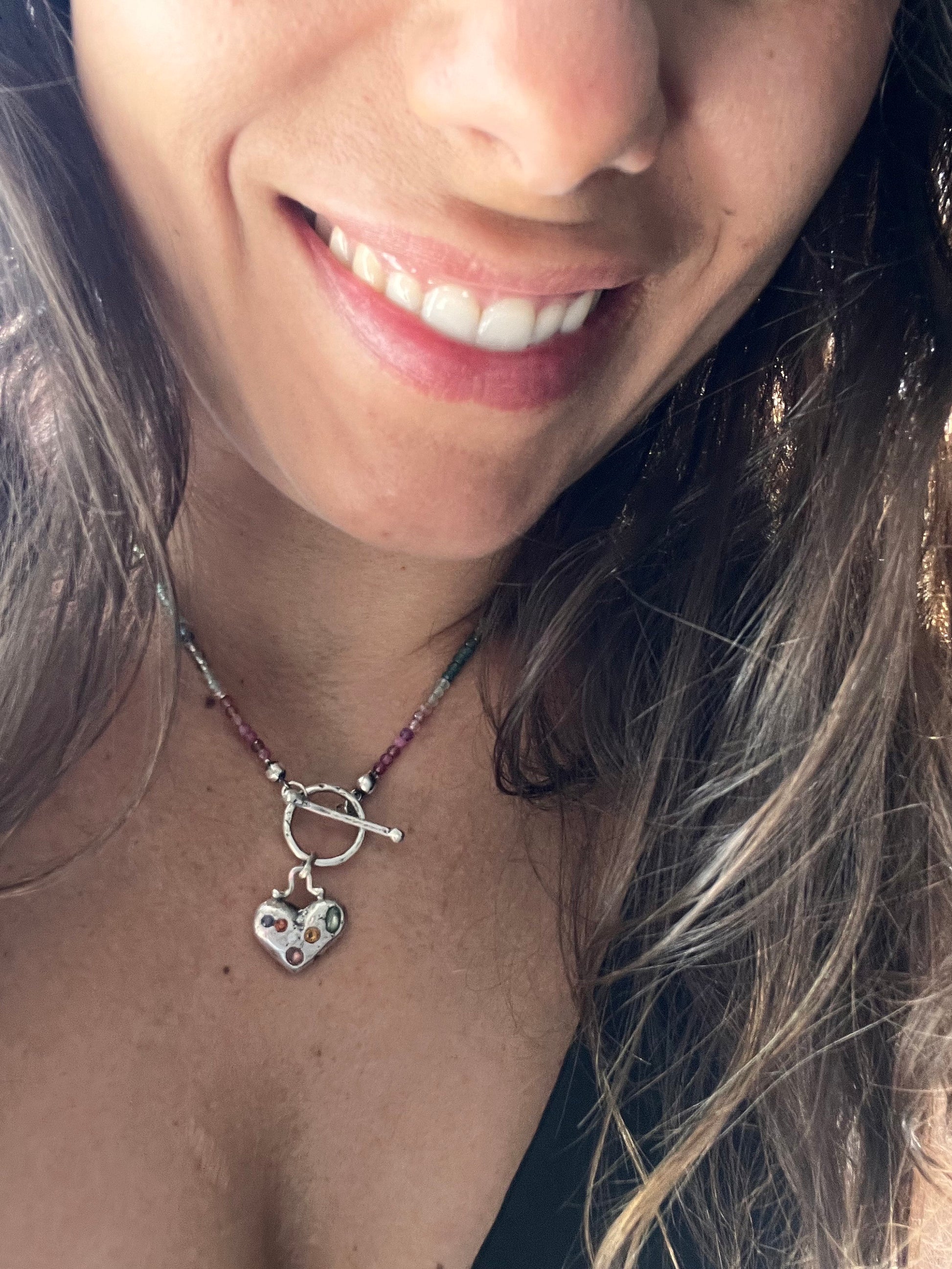 Discover our Colorful Heart Sapphire Necklace – a 15mm heart pendant adorned with seven ethically sourced sapphires, each representing a chakra. Crafted from recycled sterling silver using sand casting technique. A harmonious blend of elegance and energy.